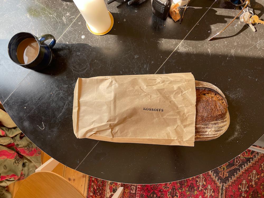 A loaf of sourdough bread in a paper bag