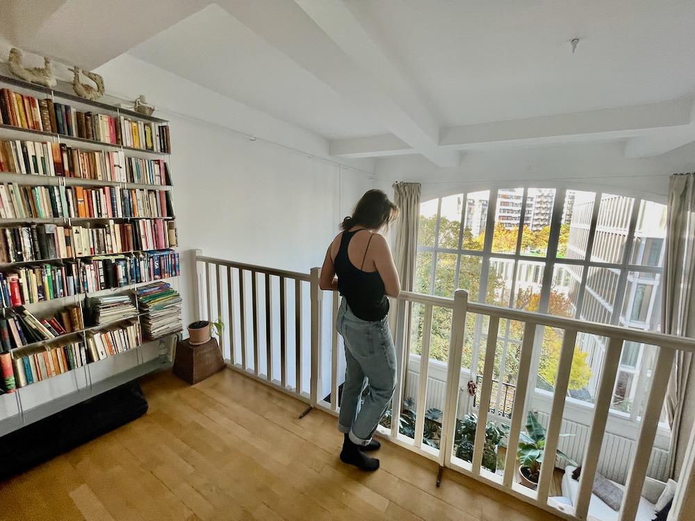 A girl standing on a mezzanine floor in an airy apartment