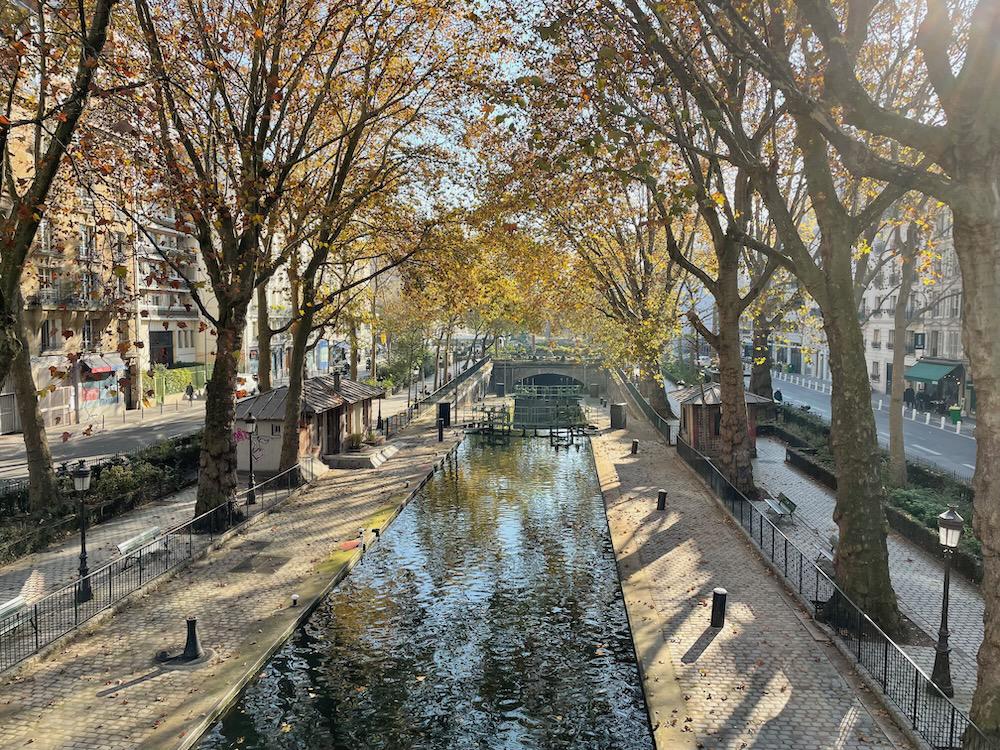 A canal with autumnal trees overhanging its banks