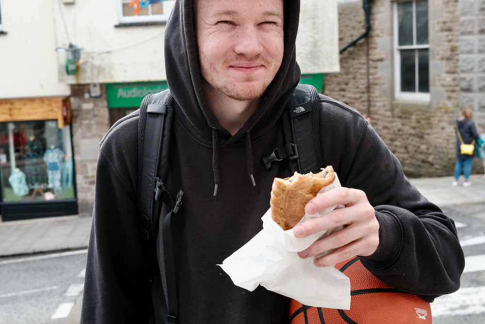 A man smiling with a pasty