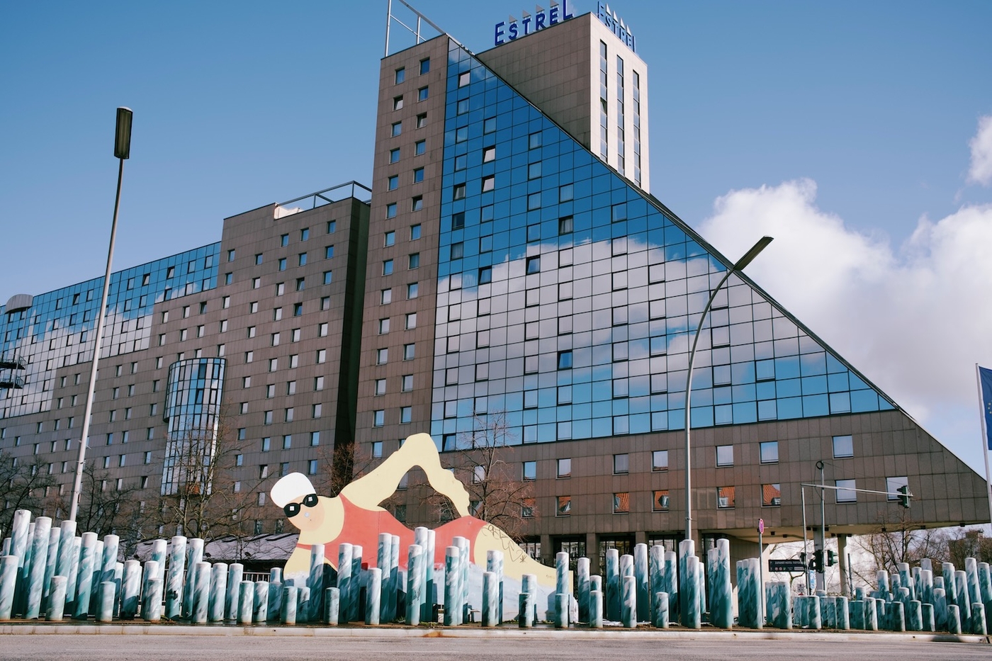 A swimmer sculpture in front of a large glass building