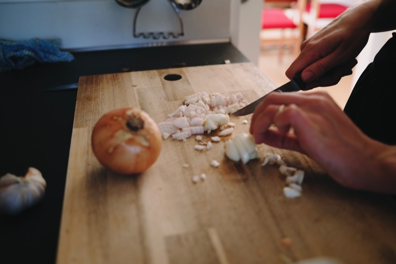 A cut white onion on a chopping board