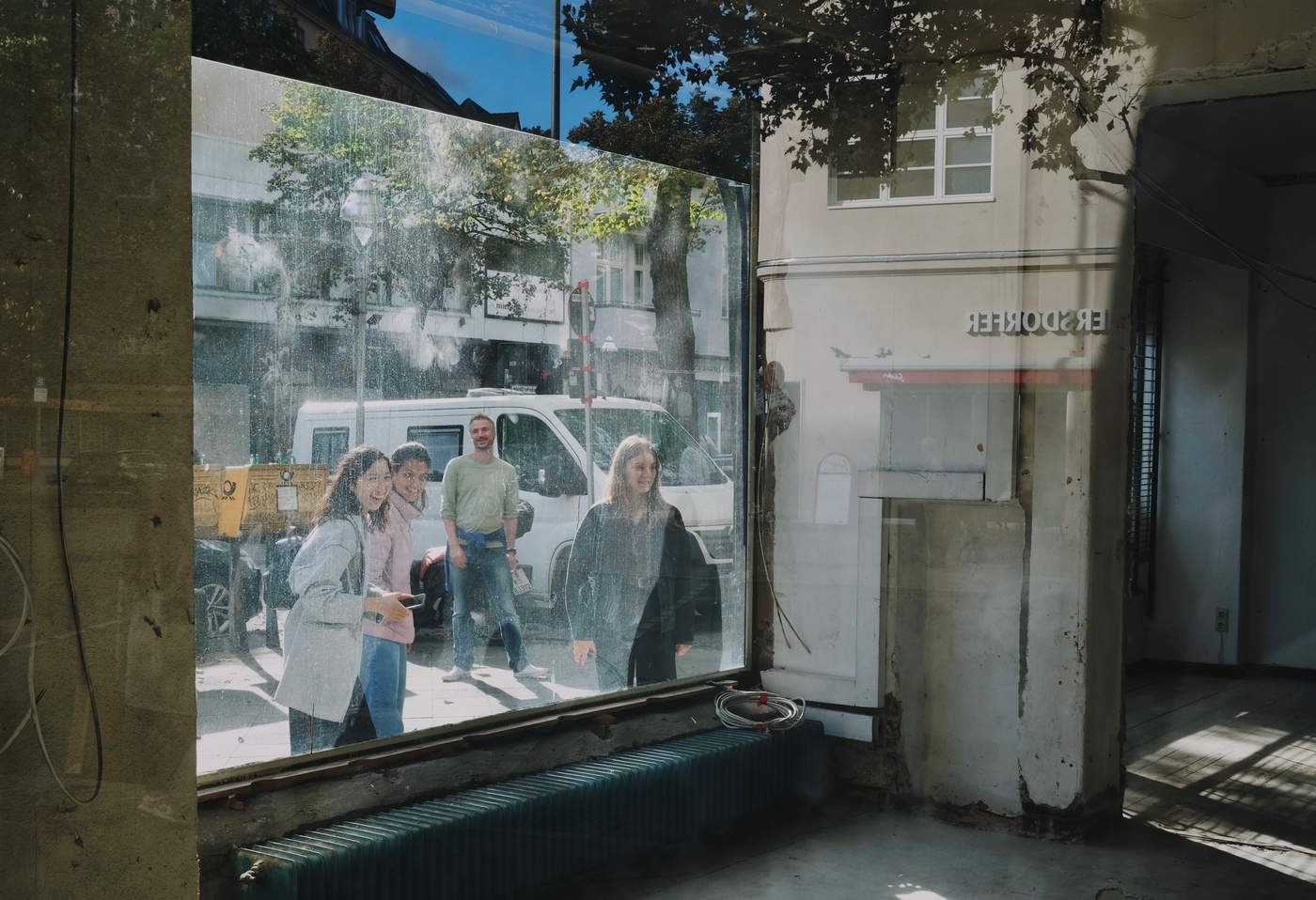 A bunch of smiling people visible through a dusty window