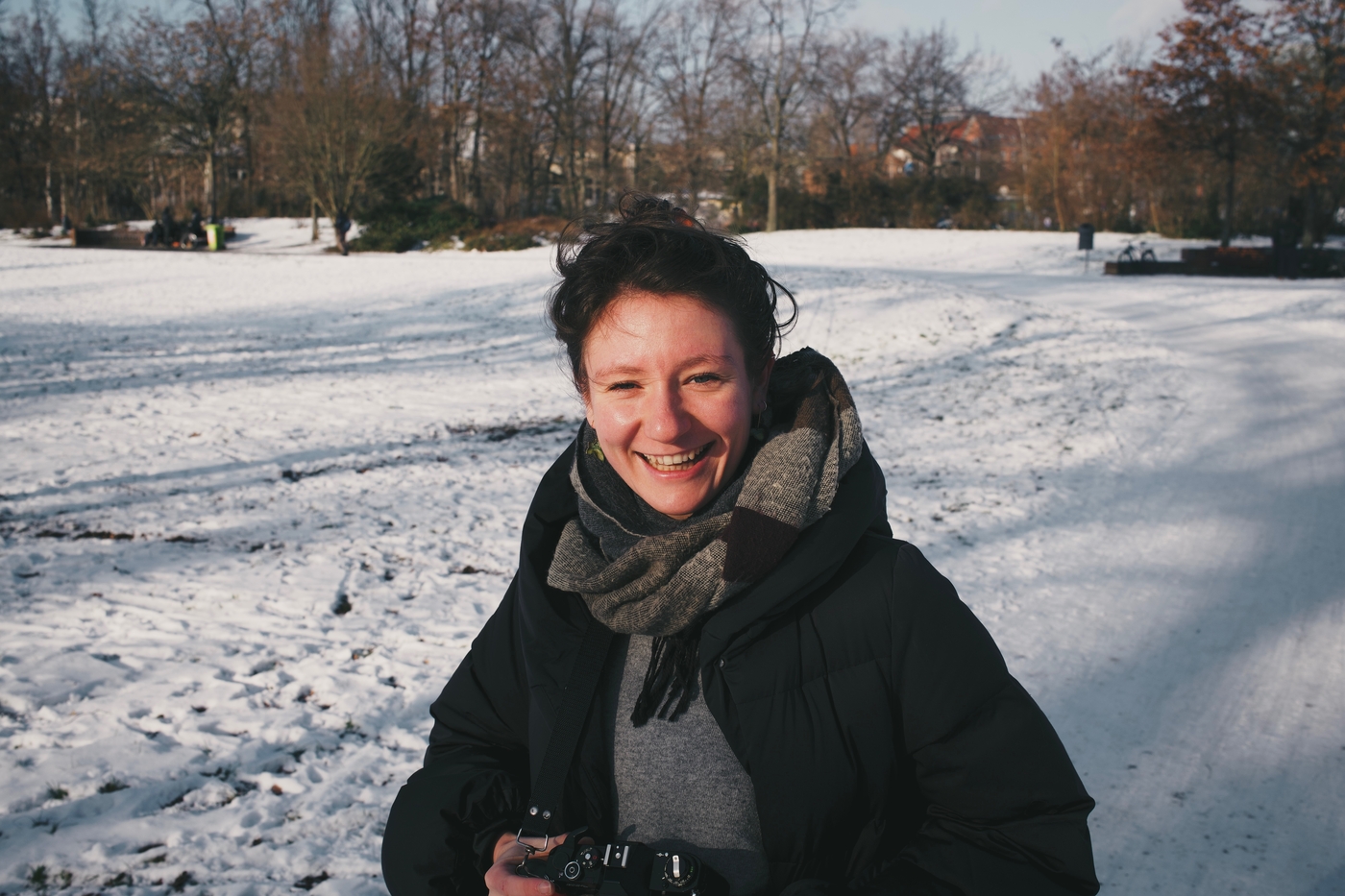 Sarah smiling in the sunshine of a snowy park