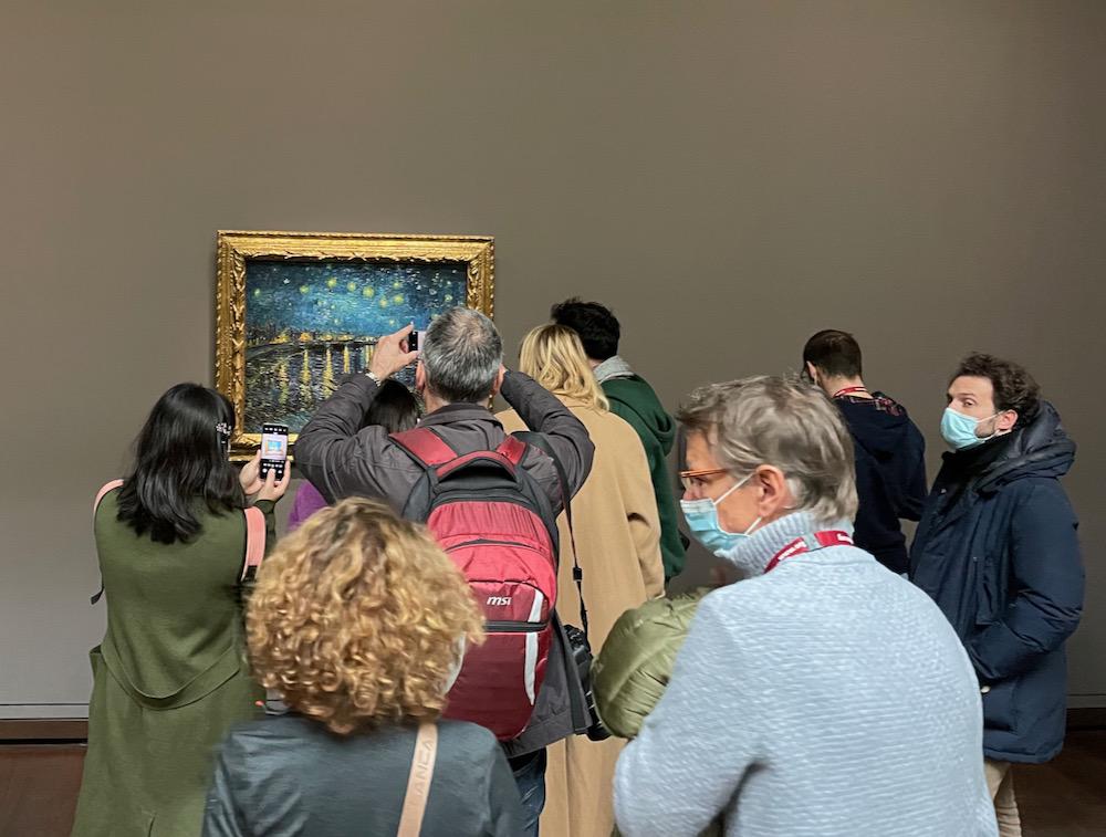 A crowd of people in front of Starry Night by Vincent Van Gogh